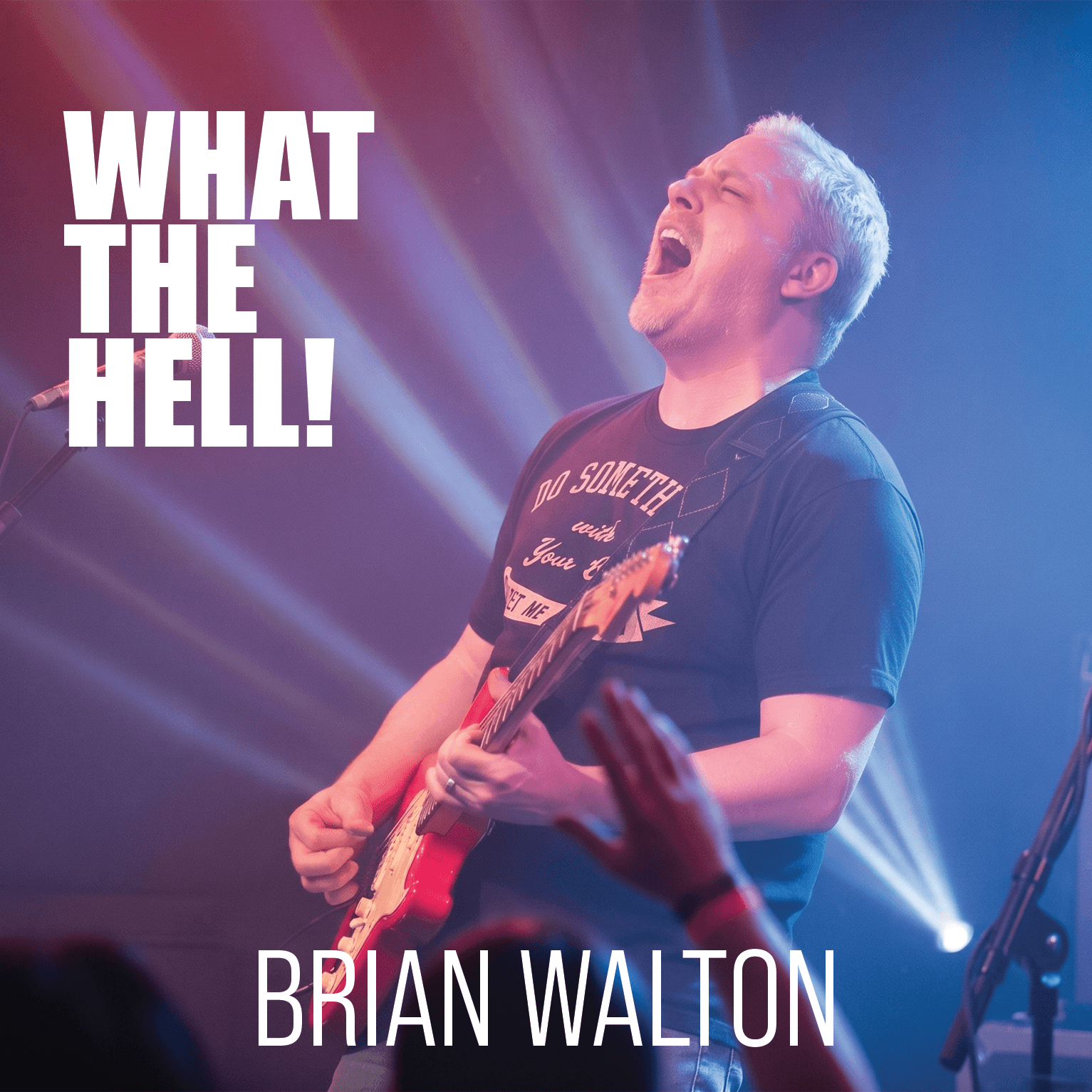 Brian Walton singing passionately while playing electric guitar on stage, with text reading What The Hell! Brian Walton